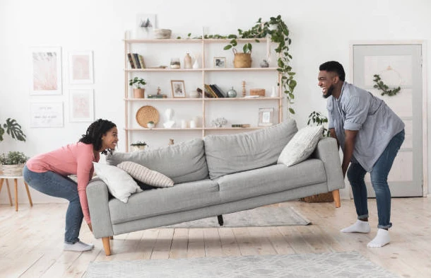 Un couple installant leur canapé neuf.