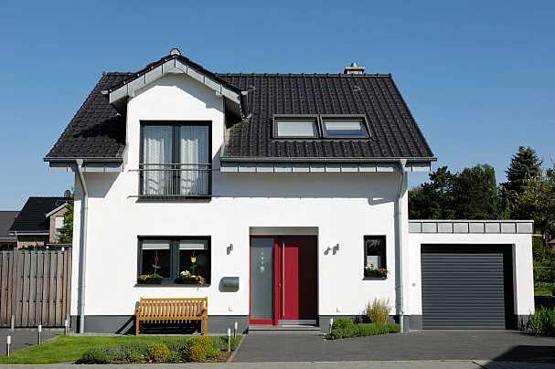 Maison neuve blanche, toit noir et porte rouge