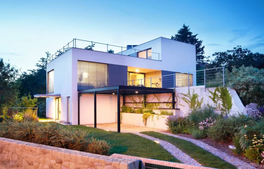 Maison moderne très éclairé avec un chemin menant au garage.